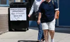  ?? BOSTON HERALD FILE ?? MAIL IT, OR DROP IT OFF: People walk by the mail-in drop box at an early voting location at the Murphy School in Dorchester on Aug. 23, 2020.