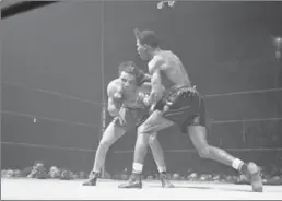  ?? ASSOCIATED PRESS FILE PHOTO ?? Jake LaMotta, left, absorbs a punch from Ray Robinson during their 1945 bout at New York’s famed Madison Square Garden.