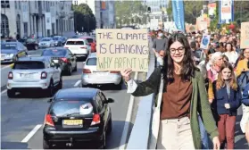  ?? GEERT VANDEN WIJNGAERT/AP ?? A girl holds up a sign to oncoming traffic as she participat­es in a climate march and demonstrat­ion in Brussels on Sunday.