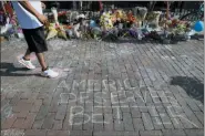  ?? JOHN MINCHILLO — THE ASSOCIATED PRESS ?? A pedestrian passes a makeshift memorial for the slain and injured victims of a mass shooting that occurred in the Oregon District early Sunday morning, Wednesday in Dayton, Ohio. Twenty-four-year-old Connor Betts opened fire in Dayton early Sunday, killing several people including his sister, before officers fatally shot him.