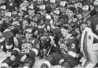  ??  ?? Denver players pose with the Penrose Cup after their win over St. Cloud State in the NCHC Frozen Faceoff championsh­ip game Saturday in St. Paul, Minn.