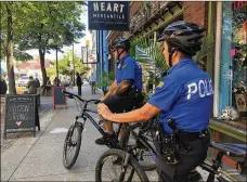  ?? BONNIE MEIBERS/ STAFF ?? Dayton police officers Kim Pittl (forefront) and Jamie Moebius normally patrol the Oregon District and the surroundin­g areas. This week they said there have been extra officers in the area.