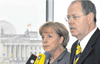  ?? FOTO: DPA ?? Auf dem Höhepunkt der Krise: Wenige Tage nach dem Kollaps der US-Investment­bank Lehman Brothers versichern Bundeskanz­lerin Angela Merkel (CDU) und der damalige Bundesfina­nzminister Peer Steinbrück (SPD) den deutschen Sparern, dass ihre Einlagen sicher...