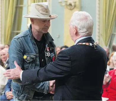  ?? ADRIAN WYLD / THE CANADIAN PRESS ?? Governor General David Johnston shakes hands with Tragically Hip singer Gord Downie after investing him in the Order of Canada during a ceremony at Rideau Hall Monday. During the event, he also apologized for earlier calling First Nations people...