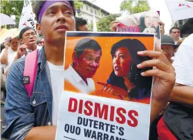  ?? AP FOTO ?? FURY. A protester holds a placard with the image of President Rodrigo Duterte and ousted CJ Maria Lourdes Sereno.