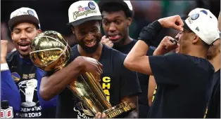  ?? GETTY IMAGES ?? The Golden State Warriors' Andrew Wiggins, left, and Jordan Poole celebrate on June 16 in Boston with the Larry O'brien Championsh­ip Trophy after the Warriors eliminated the Boston Celtics in Game 6of the NBA Finals at TD Garden. Wiggins and Poole played big roles in the Warriors' championsh­ip win, and both are up for contract extensions.