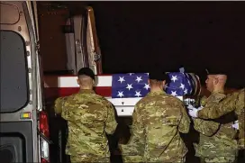  ?? MARK MAKELA / GETTY IMAGES ?? U.S. troops carry a case Tuesday during a transfer in Dover, Delaware, of fallen service member Army Ranger Sgt. Leandro Jasso, who the military says may have been killed by friendly fire.