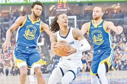  ?? AP PHOTO ?? Memphis Grizzlies guard Ja Morant, center, handles the ball between Golden State Warriors forward Andrew Wiggins (22) and guard Stephen Curry (30) during Game 1 of a second-round NBA basketball playoff series Sunday, May 1, 2022, in Memphis, Tenn.