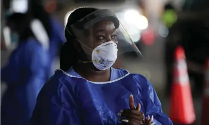  ??  ?? A healthcare worker in personal protective equipment looks on at a drive-thru Covid-19 testing site in St Petersburg, Florida. Photograph: Bryan R Smith/AFP/Getty Images