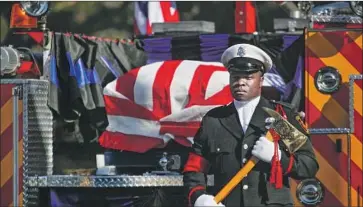  ?? Mark Boster Los Angeles Times ?? AN HONOR GUARD stands at the rear of a fire truck carrying the coffin of fallen firefighte­r Kelly Wong.