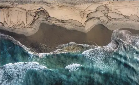  ?? WAVES CRASH Allen J. Schaben Los Angeles Times ?? into the sand after a ruptured oil pipeline sent crude gushing into the waters off Huntington Beach in October 2021.