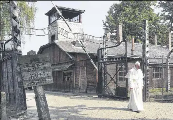  ?? CZAREK SOKOLOWSKI / ASSOCIATED PRESS ?? Pope Francis walks through the gate of the Auschwitz Nazi death camp Friday in Oswiecim, Poland. The pope later visited the gas chambers of nearby Birkenau. More than 1 million people were killed at Auschwitz.