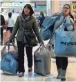  ?? KENA BETANCUR, GETTY IMAGES ?? Customers carry shopping bags at the Newport Mall during Black Friday sales on Nov. 27, 2015, in Jersey City.