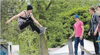  ?? STEVE HENSCHEL METROLAND ?? Branden Hodgson of Niagara Falls goes big on Saturday during the opening of a new Welland skatepark, as fellow boarders and spectators look on.