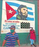  ??  ?? Men in face masks in Havana, Cuba