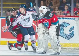  ?? MARISSA BAECKER/Shootthebr­eeze.ca ?? Kelowna Rockets captain Cal Foote, left, attempts to avoid a holding penalty while battling with Kyle Olson of the Tri-City Americans to the side of Rockets netminder James Porter during Friday’s game at Prospera Place.