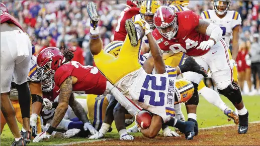  ?? KEVIN C. COX / GETTY IMAGES ?? Clyde Edwards-Helaire dives for a 1-yard touchdown during the second quarter as LSU builds a big lead in its showdown with Alabama. Edwards-Helaire scored four touchdowns, including a 7-yard run in the final minutes as the Tigers took a 12-point lead following a Crimson Tide comeback.