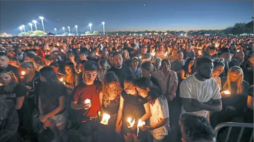  ?? Gerald Herbert/Associated Press ?? A candleligh­t vigil in Parkland, Fla., draws a crowd Thursday for the victims of the shooting at Marjory Stoneman Douglas High School.