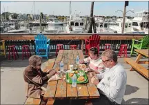  ?? DANA JENSEN/THE DAY ?? Mary Proctor, left, of New London, her daughter Nannette Sawyer and son-in-law Jay Sawyer of Norwich eat lunch at Captain Scott’s Lobster Dock in New London on Wednesday. Captain Scott’s remains open through October.