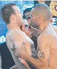  ??  ?? TENSION: Anthony Mundine (right) grabs Jeff Horn during the weigh-in yesterday.