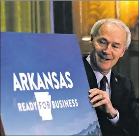  ?? (Arkansas Democrat-Gazette/Thomas Metthe) ?? Gov. Asa Hutchinson shows the slogan for the state’s plan to gradually reopen commerce. “This is a great opportunit­y for us to reengage, to rehire and start getting back to business in a phased and cautious approach,” he said during his Wednesday briefing.