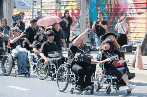  ??  ?? Disabled people in wheelchair­s head from Lat Phrao subway station to the Civil Court to file a suit against City Hall for failing to install lifts at skytrain stations.