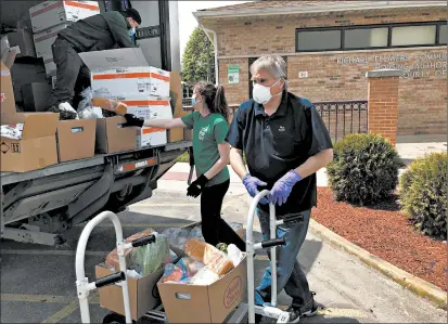  ?? TED SLOWIK/DAILY SOUTHTOWN PHOTOS ?? Richard Monocchio, Housing Authority of Cook County executive director, delivers groceries Thursday at Richard Flowers Homes in Robbins.