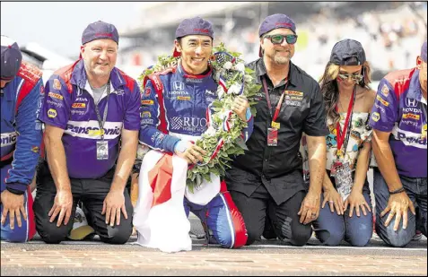  ?? CHRIS GRAYTHEN / GETTY IMAGES ?? Japanese driver Takuma Sato (center) and members of his team pay their respects at the track after the victory, which was the second straight for Andretti Autosport at the Indianapol­is 500.