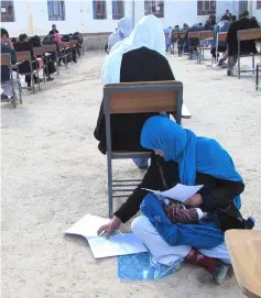  ??  ?? This photo obtained from the Facebook account of Afghan professor Yahya Erfan shows Ahmadi sitting on the ground with her baby lon her lap as she takes an entrance exam for Nasir Khusraw private university. — AFP photo