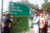  ??  ?? BJP leader Vijay Goel along with BMTA members installs a road signage after renaming it from Babar Road to 5 August Road in New Delhi on Tuesday. — G.N. JHA