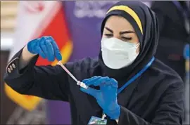  ?? Vahid Salemi Associated Press ?? A MEDIC prepares a COVID-19 vaccine. Senior Iranian officials say tens of thousands more doctors and nurses are needed to fight the pandemic in the country.