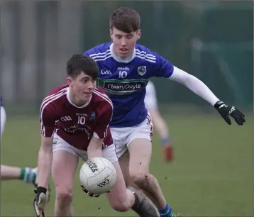  ??  ?? Luke Kavanagh (St. Martin’s) about to handpass as Glynn-Barntown’s Conor Mahoney, his St. Peter’s College team-mate, closes in.