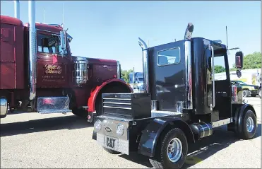  ?? Herald photos by Al Beeber ?? An electric golf cart, designed to look like a miniature semi-trailer truck, is parked beside a real big rig at the Southern Alberta Trucking Associatio­n’s fourth annual truck expo and job fair at Exhibition Park on Saturday.