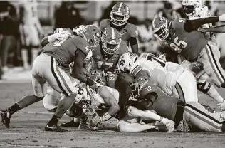  ?? Curtis Compton / Atlanta Journal-Constituti­on ?? Georgia defenders pile on Auburn quarterbac­k Bo Nix for no gain during the first quarter Saturday at Sanford Stadium. The Bulldogs have won 13 of the last 16 meetings.