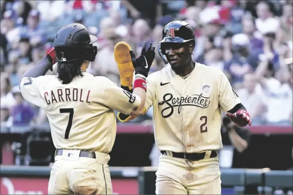  ?? ROSS D. FRANKLIN/AP ?? ARIZONA DIAMONDBAC­KS’ GERALDO PERDOMO game on Friday in Phoenix. (2) and Corbin Carroll (7) celebrate after their runs scored against the Atlanta Braves during the first inning of a