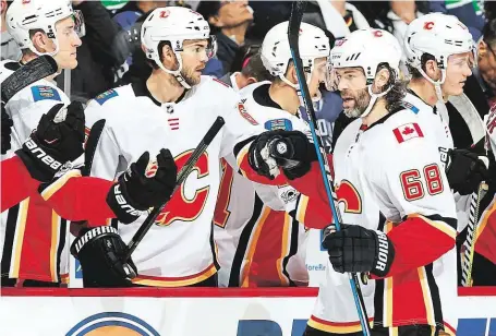  ?? Jaromír Jágr se do statistik Calgary poprvé zapsal asistencí ve třetím zápase proti Vancouveru. FOTO GETTY IMAGES ?? Gratulace novému spoluhráči.