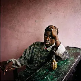  ?? Photograph: Tim Hetheringt­on/IWM ?? All in the details... a young rebel fighter in Liberia; the shot appears in the IWM show Storytelle­r.