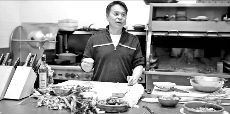  ??  ?? Charles Phan, seen at his home kitchen in 2012, helped support his family when he was a teenager. — Photos by The Slanted Door Group