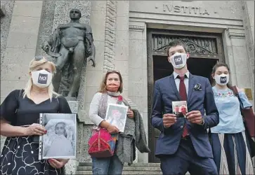  ?? Antonio Calanni Associated Press ?? RELATIVES HOLD pictures of COVID-19 victims at a courthouse in Bergamo, Italy, this month. A group of grieving families has filed dozens of complaints with the provincial prosecutor’s office against officials.