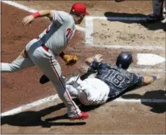  ?? GREGORY BULL — THE ASSOCIATED PRESS ?? Phillies second baseman Asdrubal Cabrera, left, leaps over the Padres’ Austin Hedges, right, after tagging Hedges out while he was trying to reach home from third on a wild pitch during the second inning Sunday in San Diego.