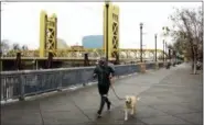  ?? RICH PEDRONCELL­I — THE ASSOCIATED PRESS ?? A man runs with his dog on the river walk along the Sacramento River, used in the movie “Lady Bird.” The location is among a number of real places features in this year’s Oscar-nominated films.