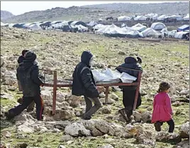  ?? AP PHOTO ?? Iraqis from the Yazidi minority carry a bed frame on Mount Sinjar in northern Iraq.