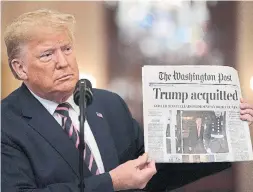  ?? DREW ANGERER GETTY IMAGES ?? In a twist ending worthy of M. Night Shyamalan, Donald Trump started his speech by holding up a copy of the Washington Post, a newspaper he condemns.