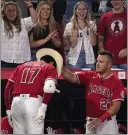 ?? MARK J. TERRILL — THE ASSOCIATED PRESS ?? The Angels' Mike Trout puts a cowboy hat on Shohei Ohtani after Ohtani hit a solo home run in the third inning.