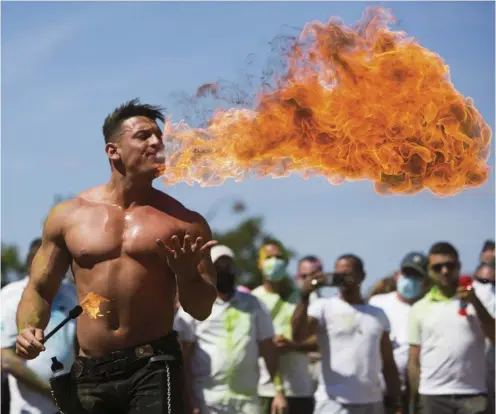  ?? RAPHAEL LAFARGUE/AGENCE FRANCE-PRESSE ?? DEMONSTRAT­ORS calling for the reopening of nightclubs in Paris gather around a fire eater performing during the protest rally.
