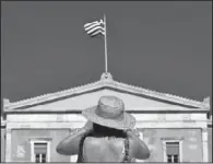  ??  ?? ELECTIONS: A tourist takes photos of the Parliament in Syntagma square Thursday in central Athens. Greece faces crucial national elections on Sunday, that could ultimately determine whether the debt- saddled, recession bound country remains in the...