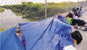  ?? ERIC GAY/ ASSOCIATED PRESS ?? Maidelen Gonzales, an immigrant from Honduras seeking asylum in the United States, waits under a tarp on the Brownsvill­e and Matamoros Internatio­nal Bridge, Friday in Matamoros, Mexico.