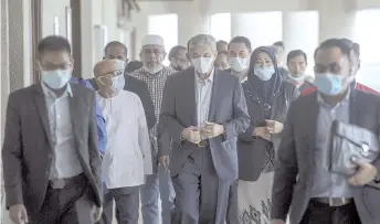  ??  ?? Zahid (center) leaving the High Court after case hearing yesterday. - Bernama photo
