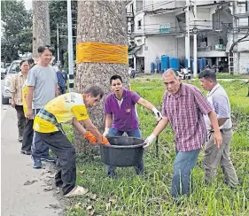  ??  ?? ABOVE AND LEFT Locals clean the area around yang naas, which have been ‘ordained’ with monk’s saffron robes to protect them from being cut down.