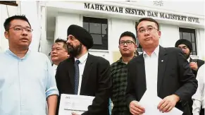  ??  ?? Taking action: Liang (right) leaving the George Town Court with Baljit (second from left) and other Gerakan members after filing the suit.